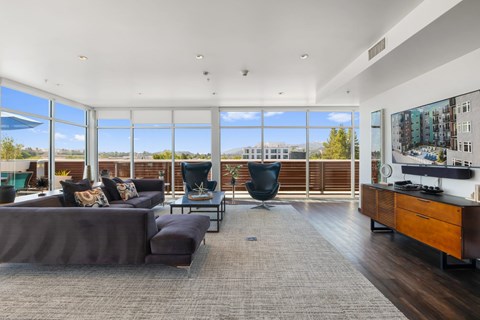 A modern living room with a large grey sofa and a black chair.