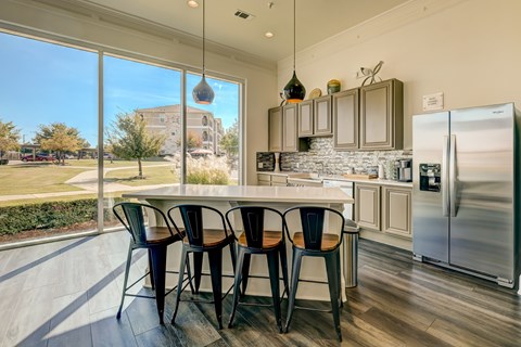 A kitchen with a table and chairs in front of a window.