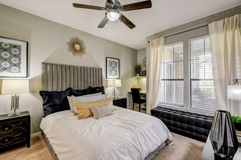A bedroom with a large bed and a ceiling fan.