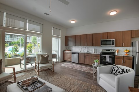A modern living room with a kitchen in the background.