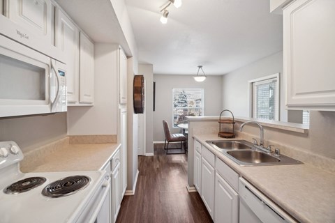 A kitchen with white cabinets and a stove top oven.