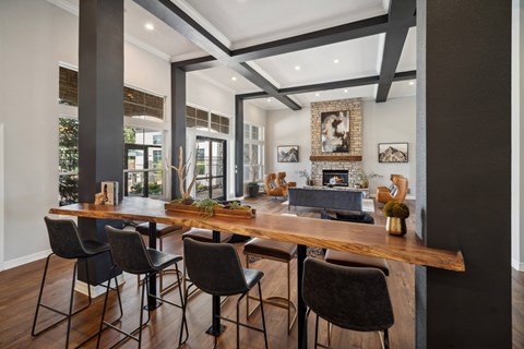 A modern dining room with a long wooden table and chairs.