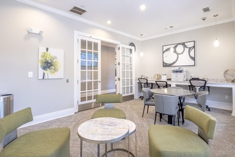 A dining room with a table surrounded by chairs.