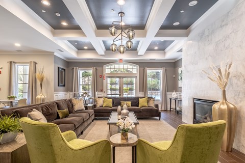 A living room with a grey couch and green chairs.