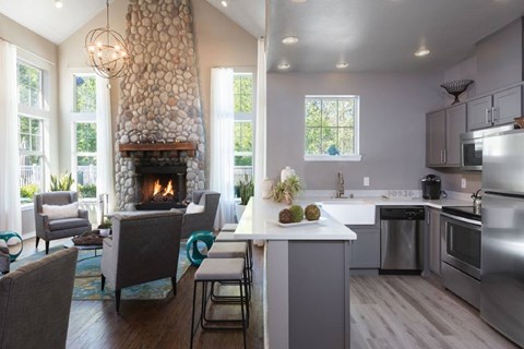 A modern kitchen with a stone fireplace and a dining table set for four.