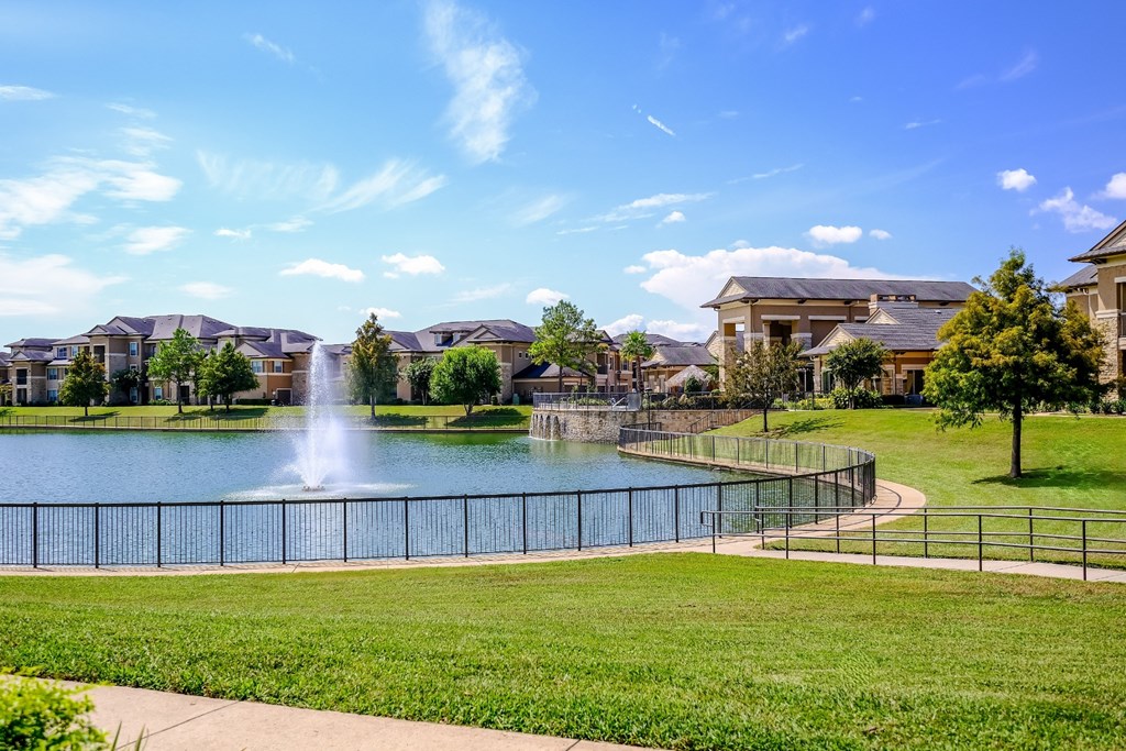 the lake with a fountain at The Falls at Copper Lake apartments