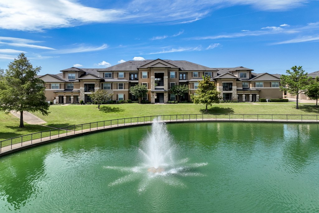 the lake with a fountain at The Falls at Copper Lake apartments