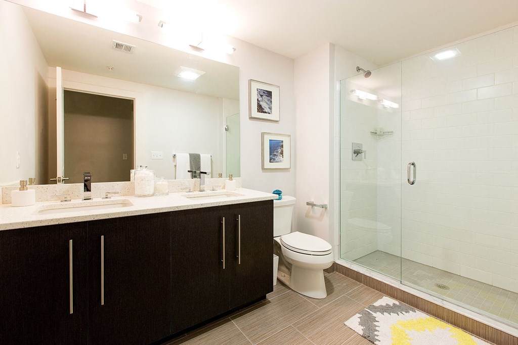 Spa Baths with Frameless Glass Shower, Beautiful Ebony Vanity with Dual Sinks, Large Mirrors and Hard Surface Flooring at Gatehouse 75, Charlestown, MA, 02129