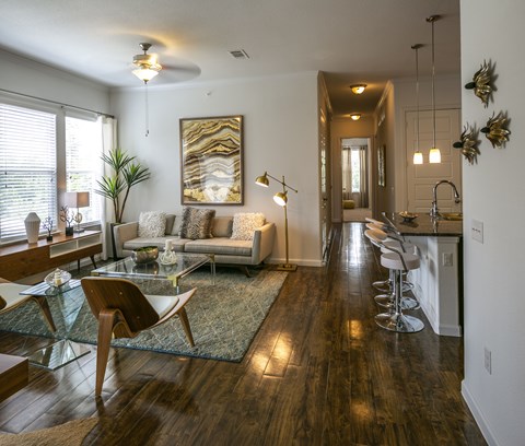 A modern living room with a glass table and a wooden chair.