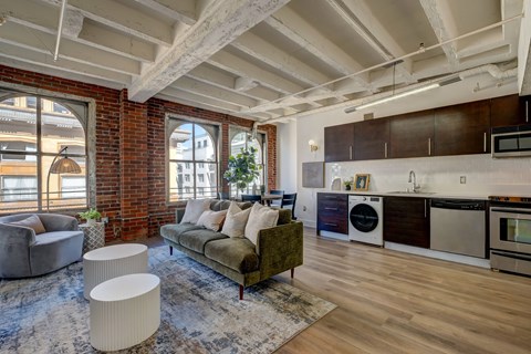 A living room with a green couch and a wooden floor.