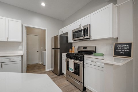 a kitchen with white cabinets and stainless steel appliances