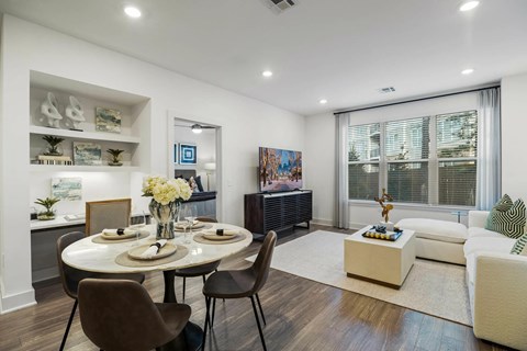 A modern dining room with a round table and chairs.