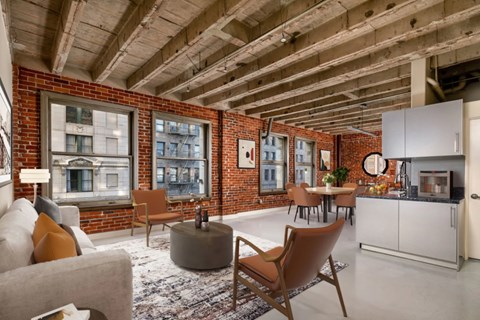 A modern living room with a brick wall and wooden ceiling.