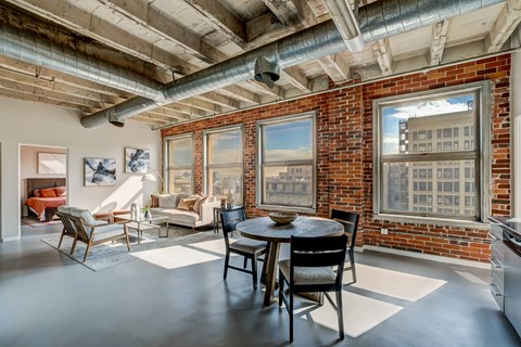 A room with a brick wall and a table with chairs.