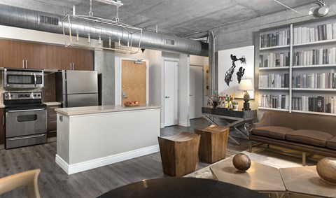 A modern kitchen with a white island and a dining table with chairs.