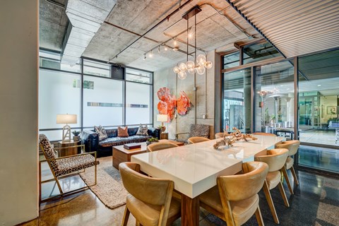 A modern dining room with a long table and chairs.