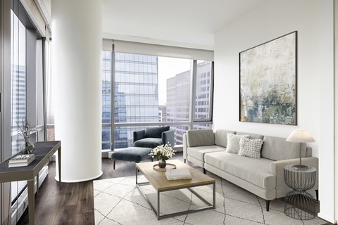 A modern living room with a large window overlooking the city.