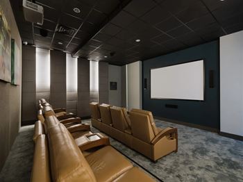 A row of brown leather seats are arranged in a theater.