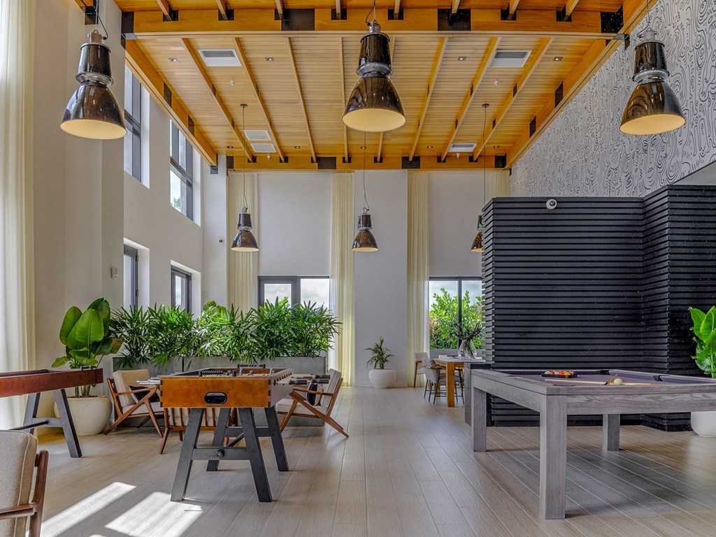 a large room with tables and chairs and a pool table