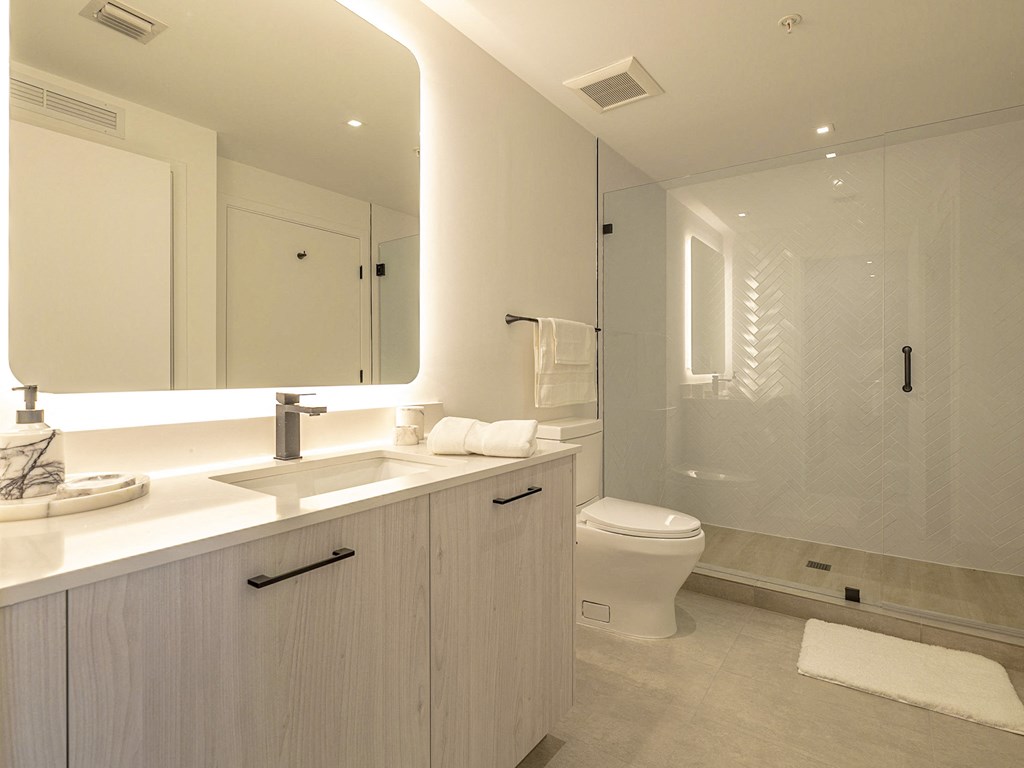 a white bathroom with a large mirror