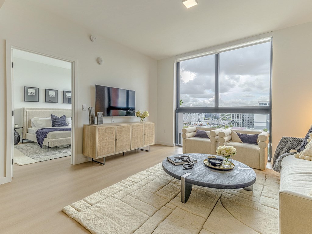 a living room with a large window and a couch and a table