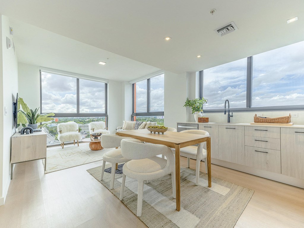 a kitchen and dining area with a table and chairs and large windows