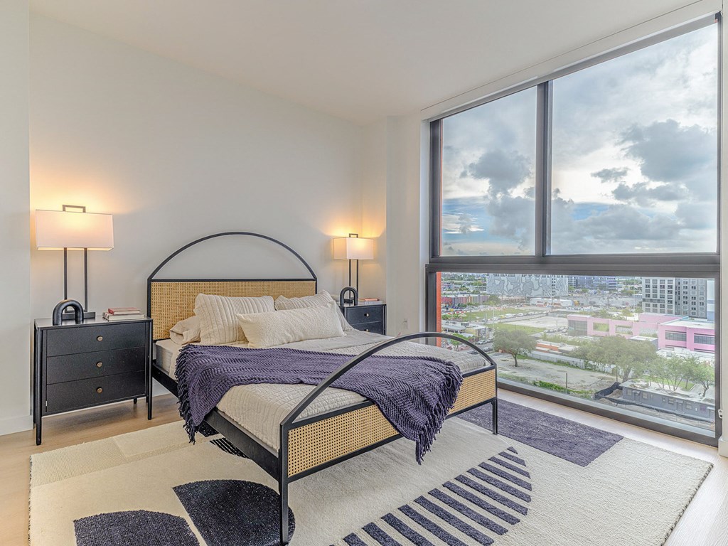 29 Wyn a bedroom with a bed and a large window with a city view