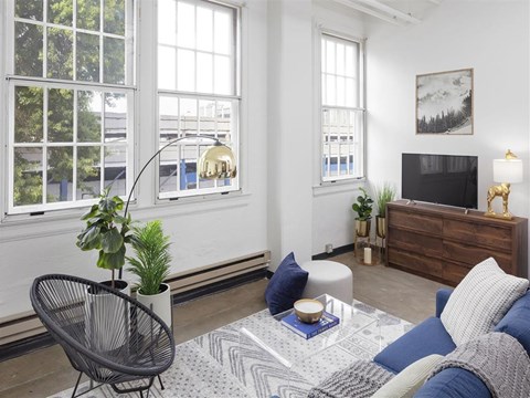 A living room with a chair, a table, a couch, and a television.