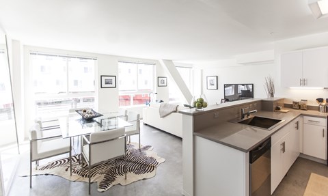 A modern kitchen with a dining table and chairs.