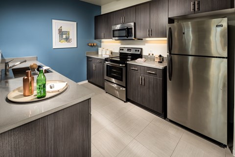 A modern kitchen with a stainless steel refrigerator and oven.