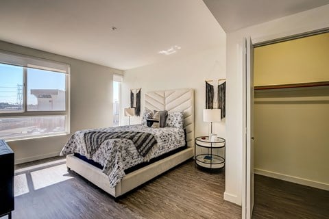 A bedroom with a large bed and a view of the outside.