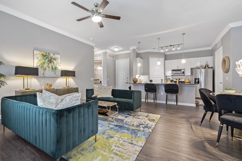 A living room with a blue couch and a ceiling fan.