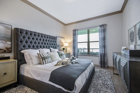 A bedroom with a large bed and a window with a view.