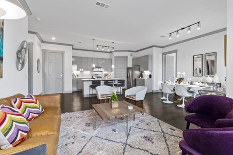 A living room with a brown couch and a white chair.