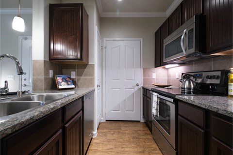 kitchen with custom cabinetry and stainless appliances at Park at Magnolia apartments