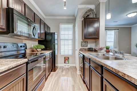A kitchen with wooden cabinets and a granite countertop.
