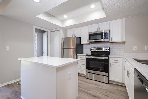 A kitchen with white cabinets and stainless steel appliances.