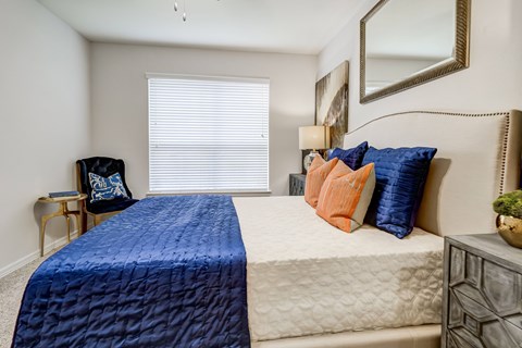 A bedroom with a blue comforter and pillows.