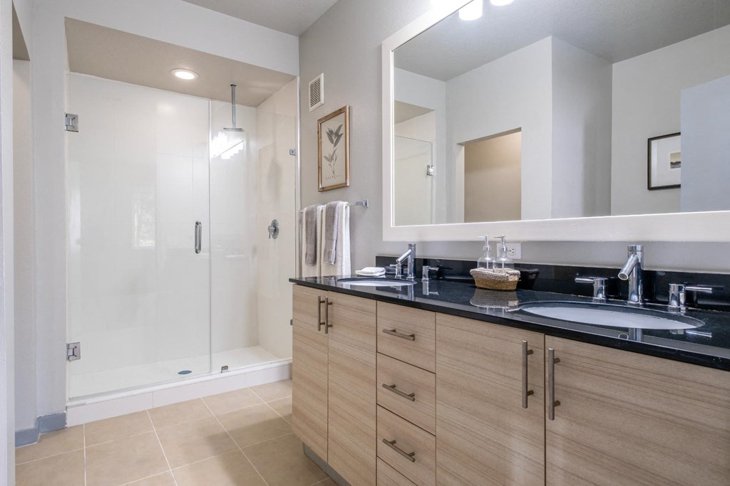 Reveal Heathrow apartments spacious bathroom with frameless glass shower