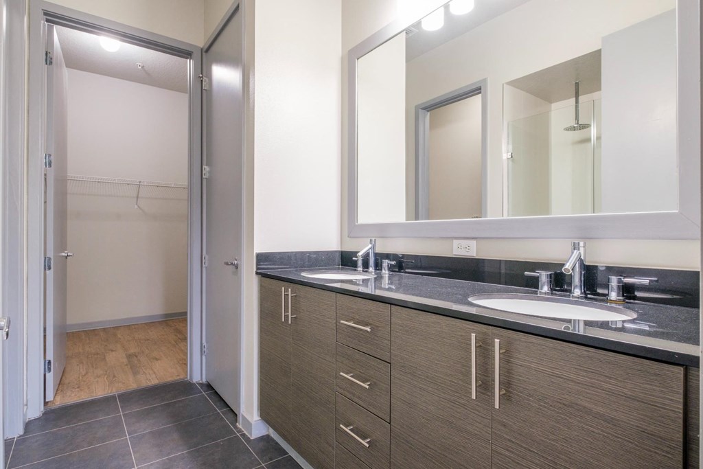 Reveal Heathrow apartment bathroom with custom cabinetry and tiled floors