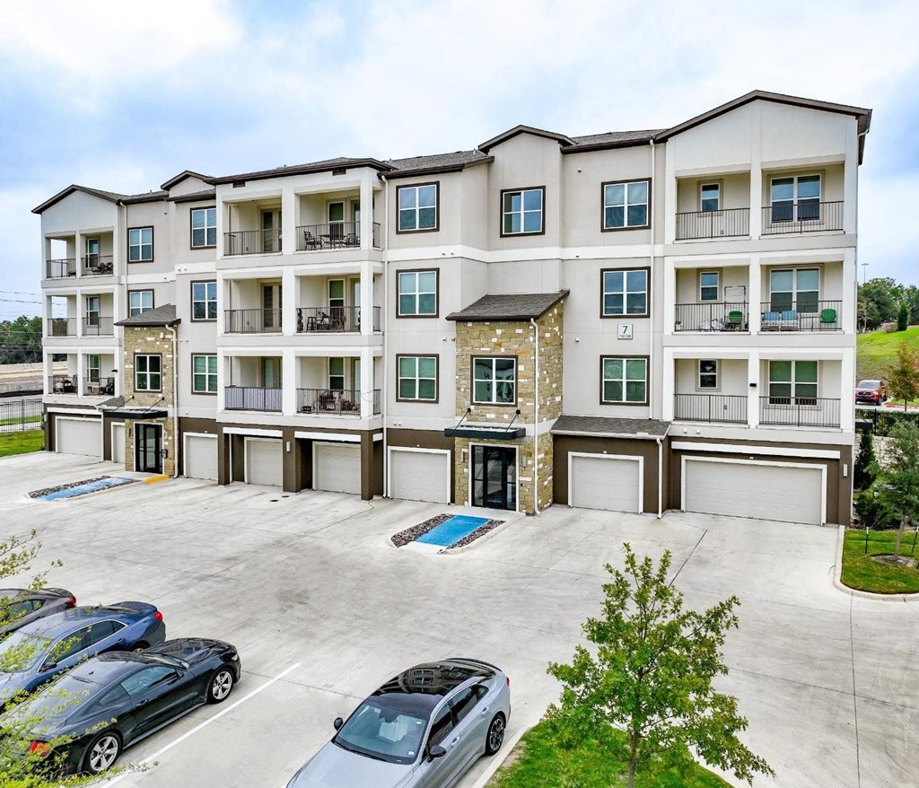 an empty parking lot in front of an apartment building