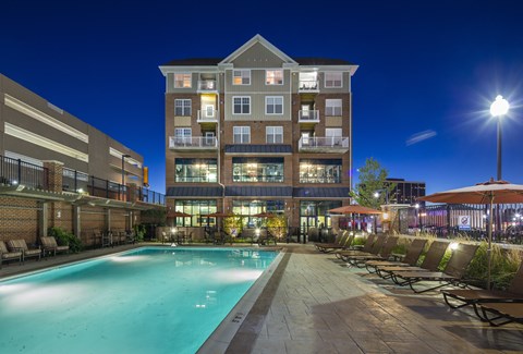 A large building with a pool in front of it.
