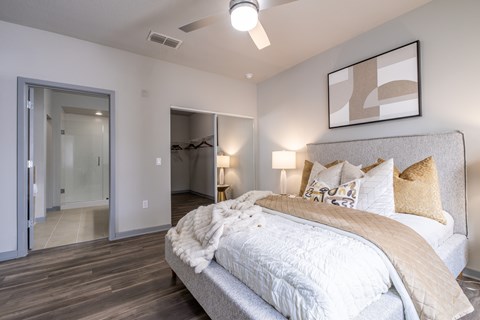 A bedroom with a large bed and a mirror on the wall.