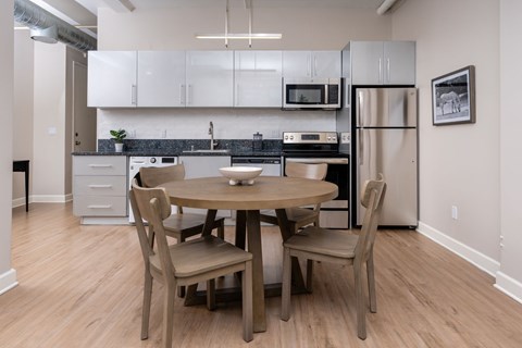 A kitchen with a table and chairs.
