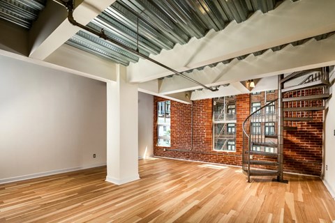 A room with wooden floors and a metal staircase.