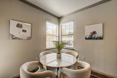A dining room with a white table and chairs.