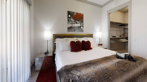 A bedroom with a large bed and a painting on the wall.