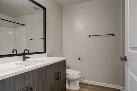 A bathroom with a toilet, sink, and towel bar.