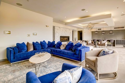 A living room with blue couches and a fireplace.