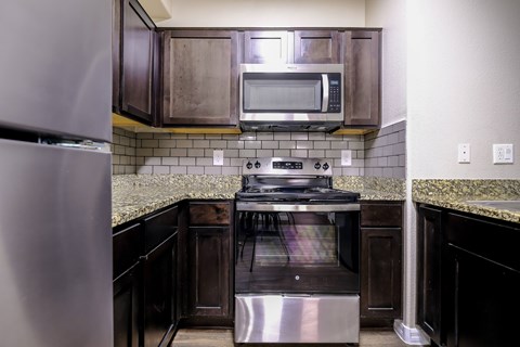 A kitchen with a stainless steel refrigerator and a stainless steel oven.
